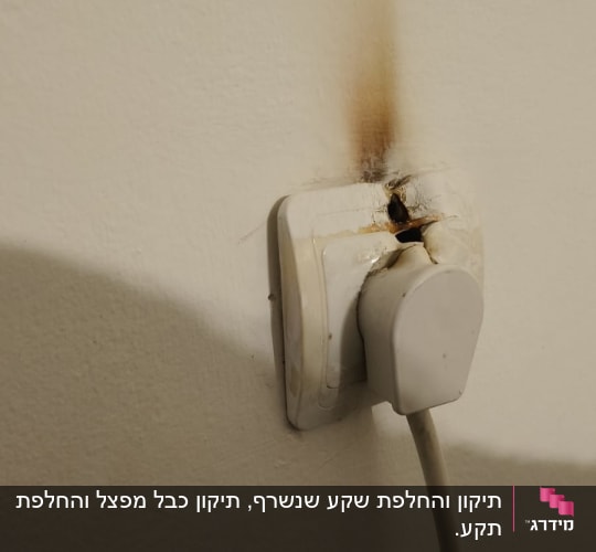 שקע חשמל עם סימני שריפה על הקיר